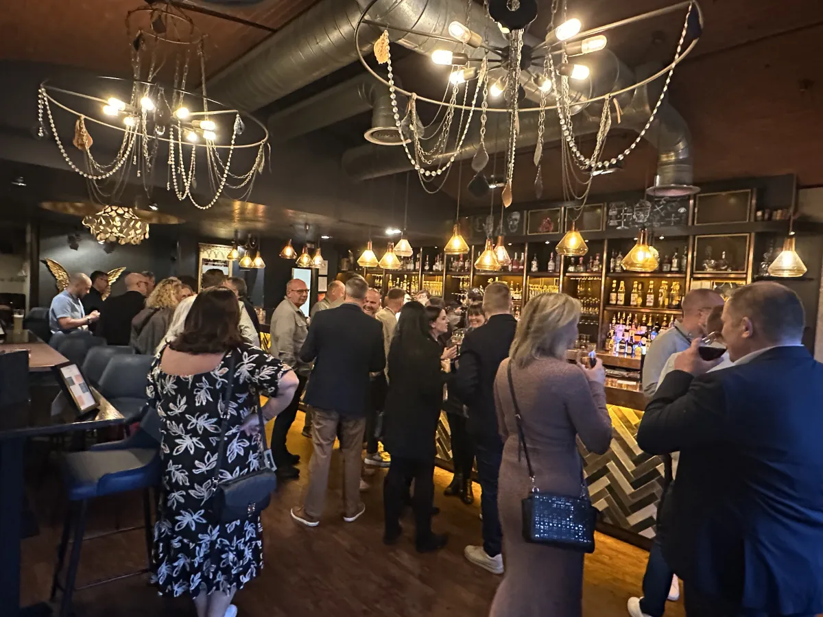 A group of operators gathers at the bar for a party at the UK user conference.